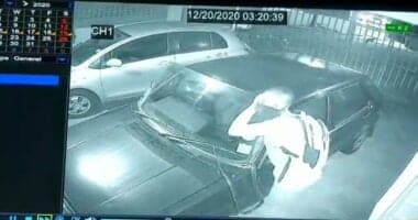 thief removing car windscreen to steal