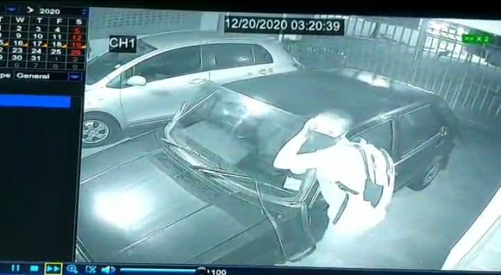 thief removing car windscreen to steal